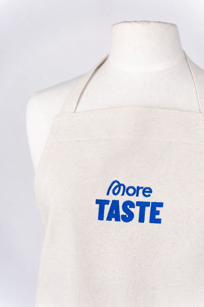 More Taste Schürze in Natur mit blauer Stickerei, Vorderansicht am Mannequin